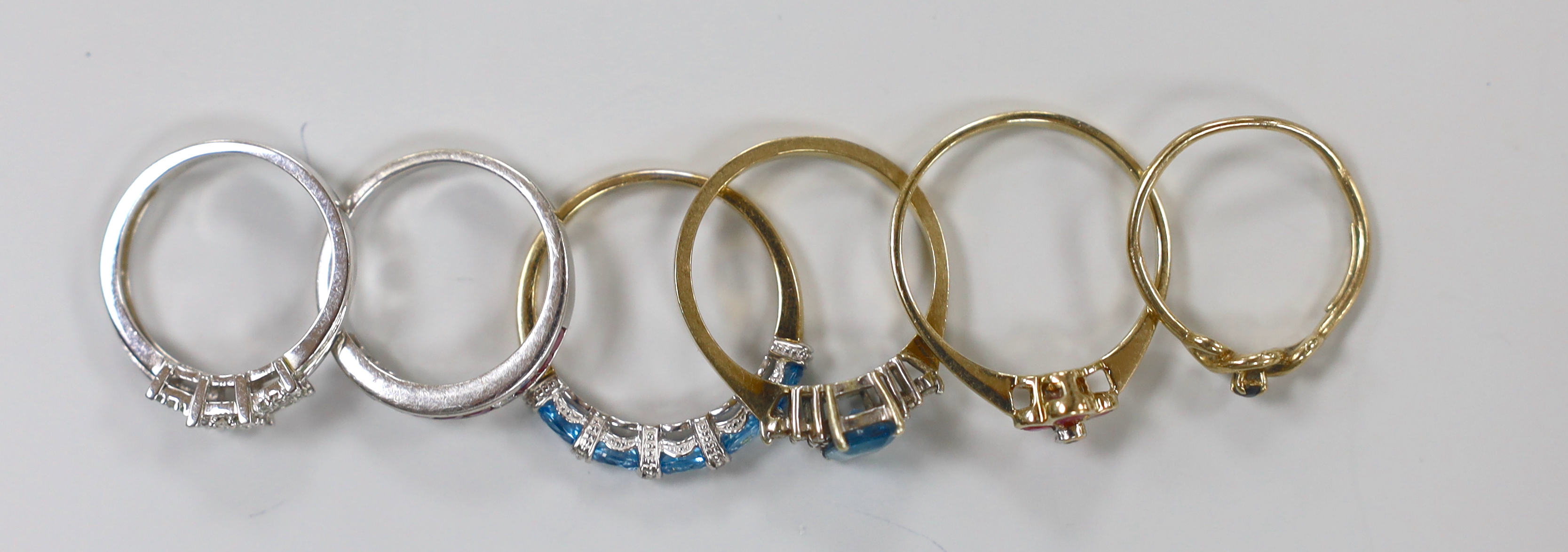 A modern 9ct white gold and diamond chip triple square cluster ring and a similar ruby and diamond set half hoop ring, together with four assorted modern 9ct gold and gem set rings, gross weight 11.2 grams.